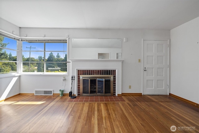 8403 36th Ave SW, Seattle, WA 98126 - unfurnished living room with hardwood / wood-style floors and a brick fireplace