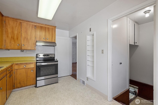 8403 36th Ave SW, Seattle, WA 98126 - kitchen with stainless steel range with electric stovetop, under cabinet range hood, brown cabinetry, and light countertops