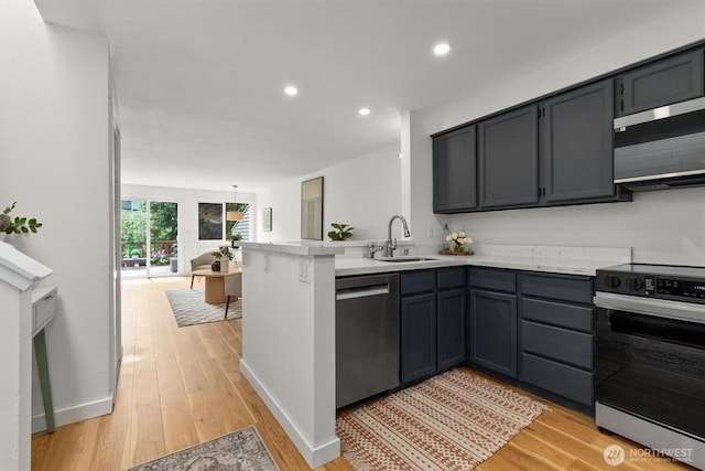 9641 NE 121st Ln, Kirkland, WA 98034 - kitchen with appliances with stainless steel finishes, a peninsula, light wood finished floors, recessed lighting, and open floor plan