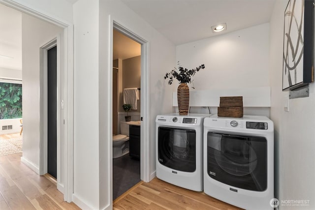 9641 NE 121st Ln, Kirkland, WA 98034 - washroom featuring washer and dryer, light wood-style flooring, and recessed lighting