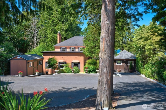 19453 Military Rd S, Seatac, WA 98188 - view of front facade with a chimney, stucco siding, and a storage unit