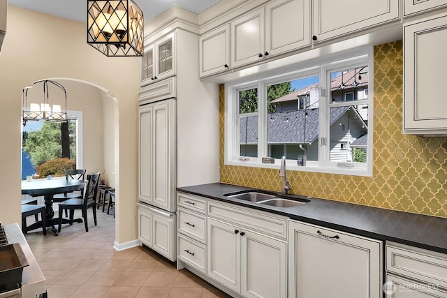 19453 Military Rd S, Seatac, WA 98188 - kitchen with dark countertops, light tile patterned floors, arched walkways, paneled built in refrigerator, and plenty of natural light