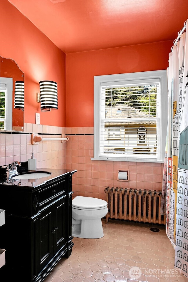19453 Military Rd S, Seatac, WA 98188 - bathroom with radiator heating unit, vanity, tile patterned flooring, tile walls, and a wainscoted wall