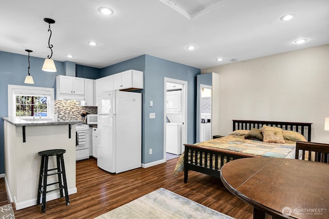 19453 Military Rd S, Seatac, WA 98188 - bedroom featuring freestanding refrigerator, estacked washer and dryer, dark wood-style flooring, and recessed lighting