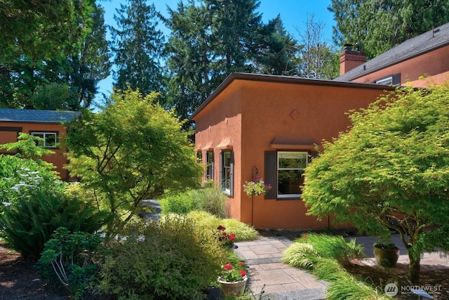 19453 Military Rd S, Seatac, WA 98188 - view of home's exterior featuring stucco siding and a chimney
