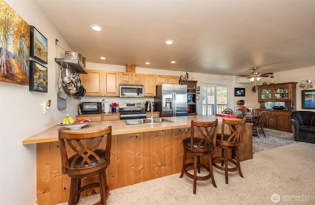 70 Onyx Ln, Sequim, WA 98382 - kitchen featuring appliances with stainless steel finishes, a breakfast bar area, light colored carpet, light countertops, and recessed lighting