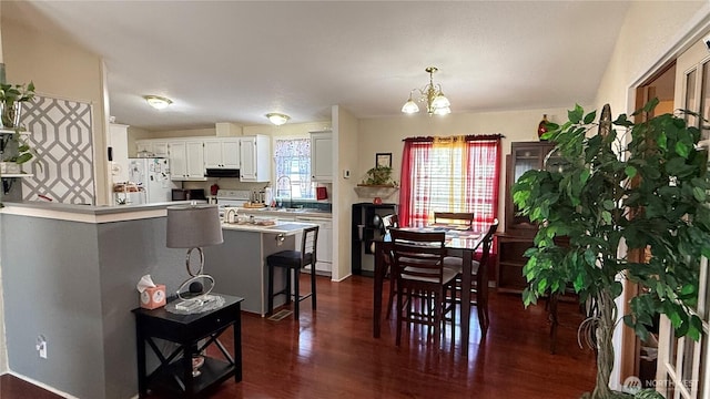 10426 11th Avenue Ct S, Tacoma, WA 98444 - dining area featuring dark wood finished floors and a chandelier