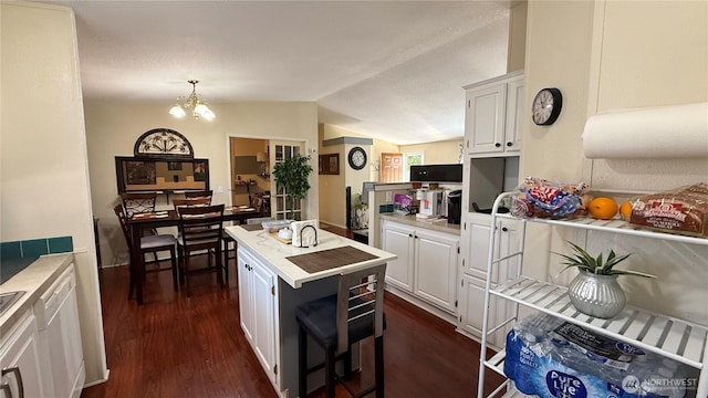10426 11th Avenue Ct S, Tacoma, WA 98444 - kitchen with lofted ceiling, white cabinetry, dark wood-style flooring, a chandelier, and light countertops