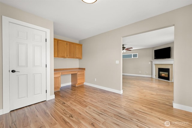 6209 Lincoln Dr, Ferndale, WA 98248 - kitchen featuring built in study area, light wood-type flooring, a ceiling fan, and a fireplace with flush hearth