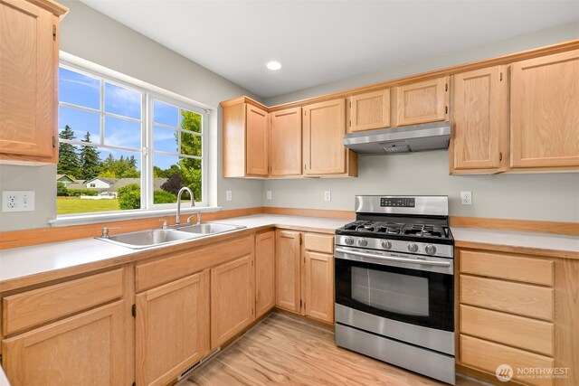 6209 Lincoln Dr, Ferndale, WA 98248 - kitchen with light brown cabinetry, gas range, under cabinet range hood, light countertops, and recessed lighting