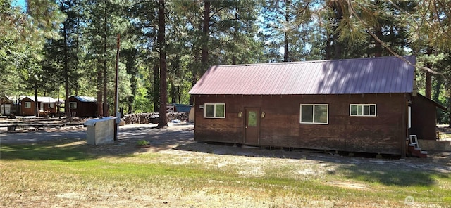 67 Northcott Rd, Winthrop, WA 98862 - view of property exterior featuring a metal roof and a lawn