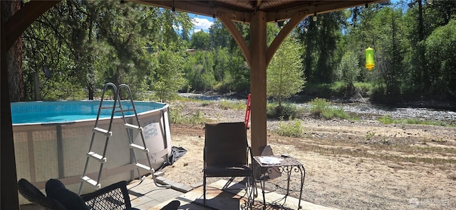 67 Northcott Rd, Winthrop, WA 98862 - view of patio / terrace with an outdoor pool and view of wooded area