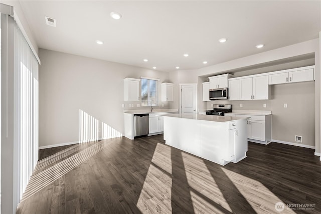 3913 23rd Ave NE Unit 97, Olympia, WA 98516 - kitchen featuring appliances with stainless steel finishes, dark wood-type flooring, light countertops, white cabinetry, and recessed lighting