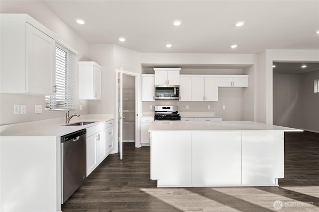 3913 23rd Ave NE Unit 97, Olympia, WA 98516 - kitchen featuring appliances with stainless steel finishes, dark wood-style flooring, white cabinets, a center island, and light countertops