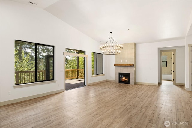 1450 Nelson Siding, Cle Elum, WA 98922 - unfurnished living room featuring a chandelier, light wood-style floors, lofted ceiling, and a tiled fireplace