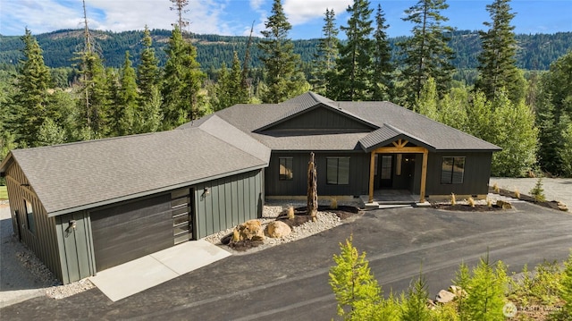 1450 Nelson Siding, Cle Elum, WA 98922 - view of front of property with a forest view, driveway, a shingled roof, a garage, and covered porch