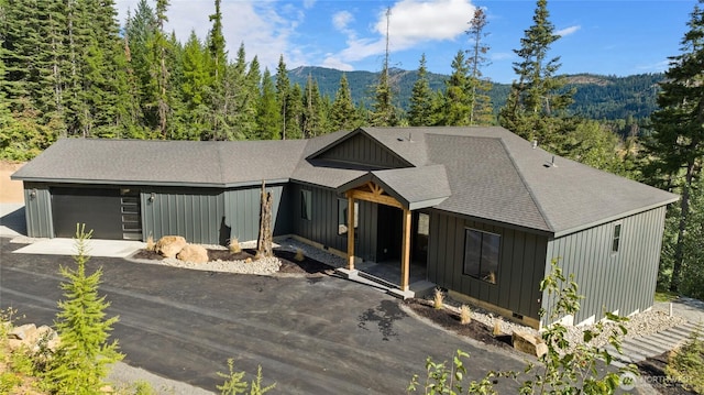 1450 Nelson Siding, Cle Elum, WA 98922 - view of front of home featuring board and batten siding, a mountain view, a garage, driveway, and a shingled roof