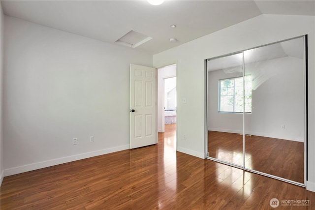 2025 Palisade Blvd, Dupont, WA 98327 - unfurnished bedroom featuring attic access, wood finished floors, vaulted ceiling, and a closet