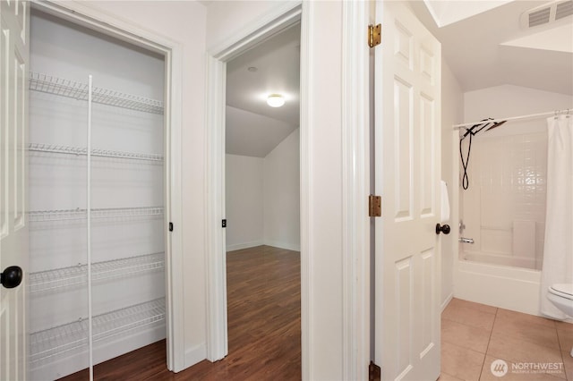 2025 Palisade Blvd, Dupont, WA 98327 - bathroom featuring lofted ceiling, shower / bath combo with shower curtain, and wood finished floors