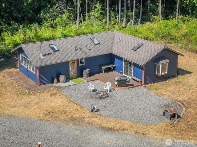 19002 Sorenson Rd SE, Yelm, WA 98597 - view of front of home featuring an outdoor fire pit, a shingled roof, a wooden deck, and a patio area