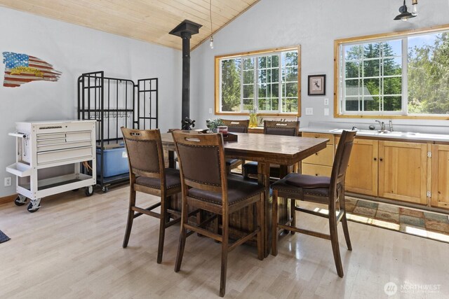 19002 Sorenson Rd SE, Yelm, WA 98597 - dining area with light wood-type flooring, wooden ceiling, a wood stove, and high vaulted ceiling