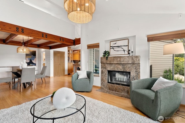 10036 NE 115th Ln Unit A3, Kirkland, WA 98033 - living area with wood finished floors, a tile fireplace, beam ceiling, and a chandelier