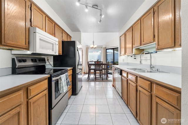 4051 S 159th Ln, Tukwila, WA 98188 - kitchen with stainless steel appliances, light tile patterned floors, light countertops, a chandelier, and brown cabinetry