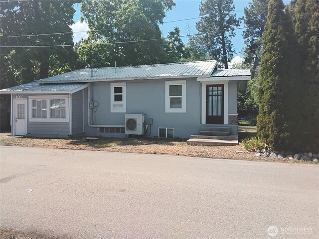 306 Henderson Way E, Tonasket, WA 98855 - view of front of house featuring entry steps, a metal roof, and stucco siding