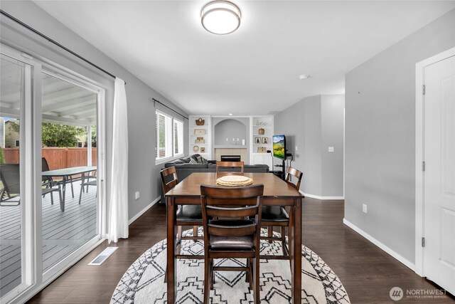 6815 278th St NW, Stanwood, WA 98292 - dining room with a tile fireplace, dark wood-style flooring, and built in features