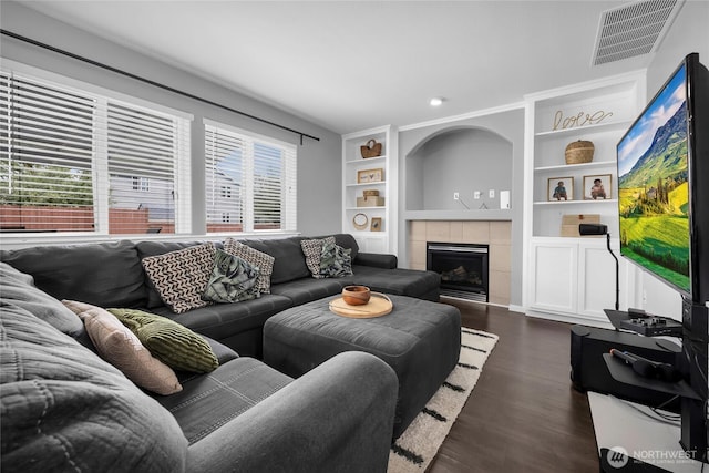6815 278th St NW, Stanwood, WA 98292 - living area featuring dark wood-type flooring, a tiled fireplace, and built in features