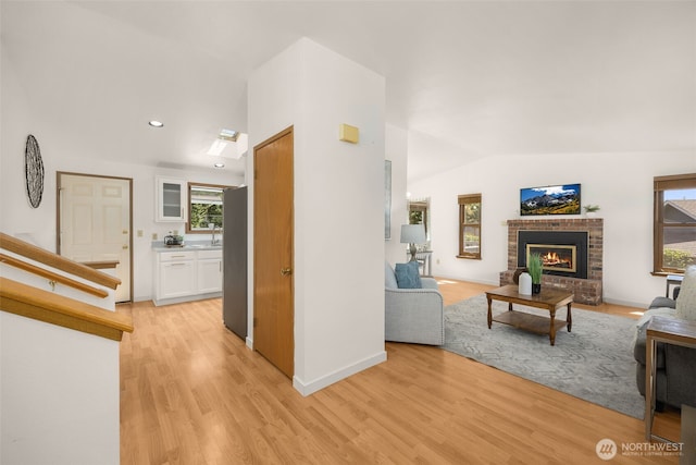 8833 47th Pl W, Mukilteo, WA 98275 - living room featuring lofted ceiling, light wood-type flooring, a brick fireplace, and recessed lighting