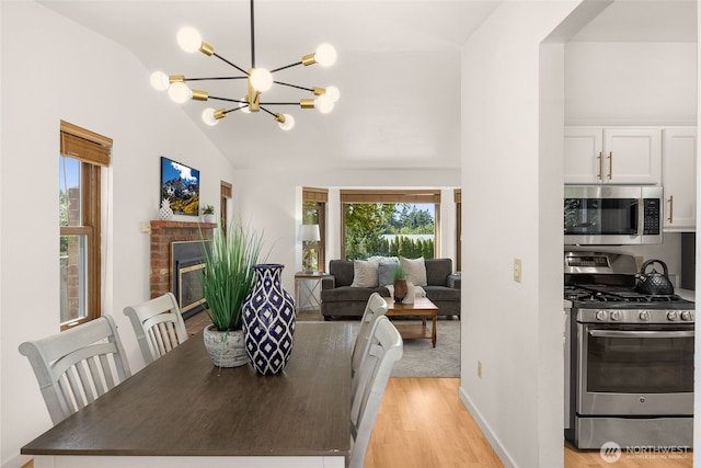 8833 47th Pl W, Mukilteo, WA 98275 - dining area with lofted ceiling, light wood-style floors, a chandelier, and a fireplace