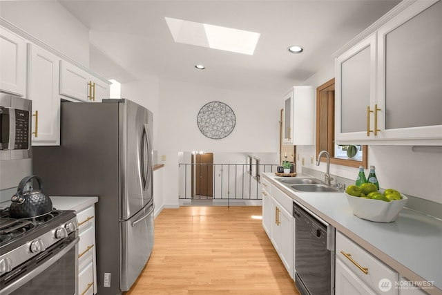 8833 47th Pl W, Mukilteo, WA 98275 - kitchen featuring appliances with stainless steel finishes, a skylight, light countertops, light wood-type flooring, and recessed lighting
