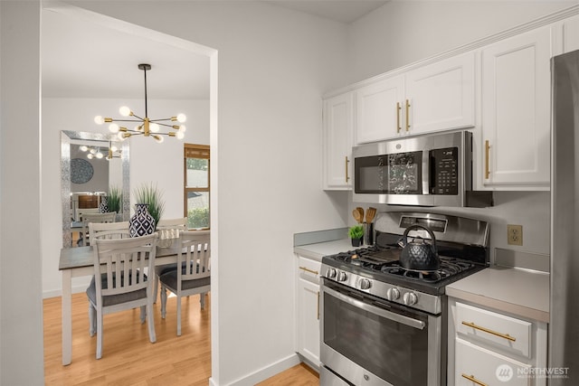 8833 47th Pl W, Mukilteo, WA 98275 - kitchen with appliances with stainless steel finishes, a chandelier, white cabinetry, and light wood-style flooring