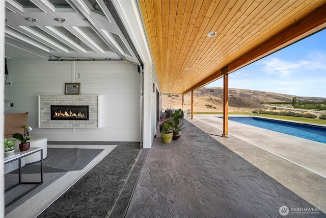 451S Partridge Ln, East Wenatchee, WA 98802 - view of patio / terrace with a mountain view, an outdoor pool, and an outdoor brick fireplace