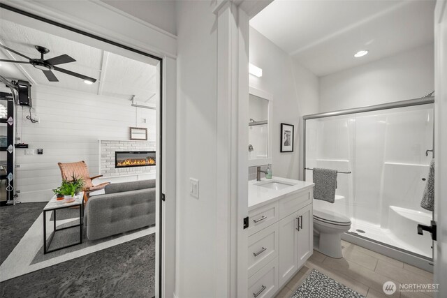 451S Partridge Ln, East Wenatchee, WA 98802 - bathroom featuring vanity, a shower stall, a fireplace, a ceiling fan, and tile patterned flooring