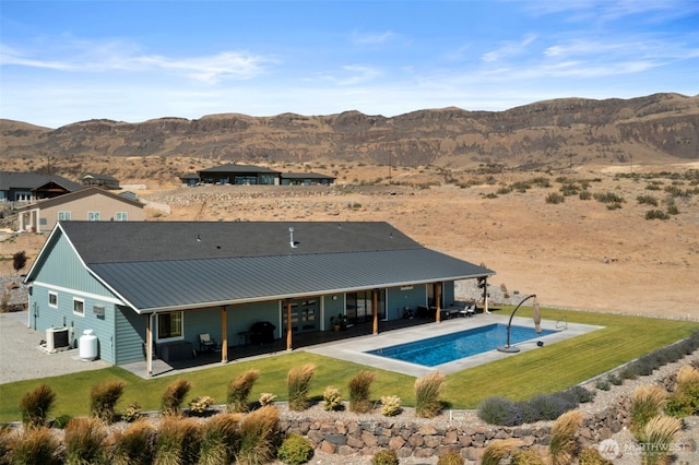 451S Partridge Ln, East Wenatchee, WA 98802 - back of property featuring a patio, a mountain view, a lawn, an outdoor pool, and a metal roof