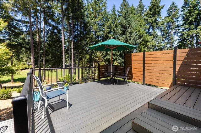 81 E Dunoon Pl, Shelton, WA 98584 - wooden terrace featuring outdoor dining space and view of scattered trees