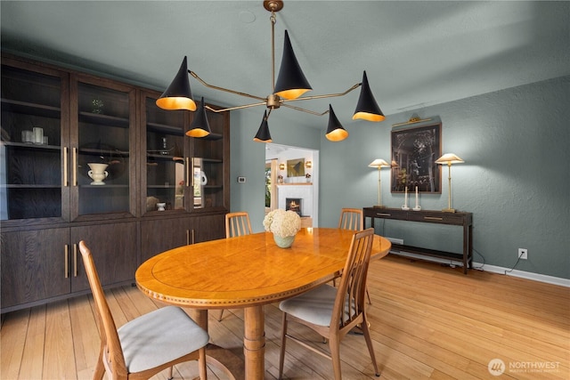 4315 52nd Ave NE, Seattle, WA 98105 - dining area featuring a lit fireplace, light wood finished floors, and a textured wall