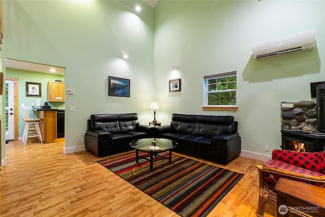 7493 Miller Way, Deming, WA 98244 - living area featuring high vaulted ceiling, a wood stove, light wood-style flooring, and a wall unit AC