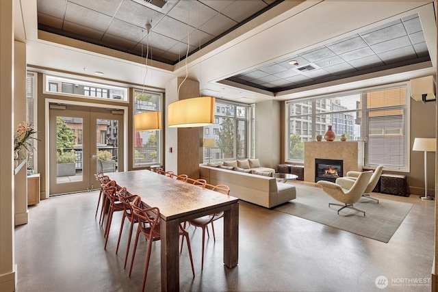 2801 1st Ave Unit 501, Seattle, WA 98121 - dining space with a tray ceiling, a drop ceiling, concrete floors, a high end fireplace, and french doors