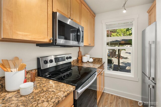 8615 238th St SW Unit B202, Edmonds, WA 98026 - kitchen featuring appliances with stainless steel finishes, light wood finished floors, light brown cabinets, and light stone counters