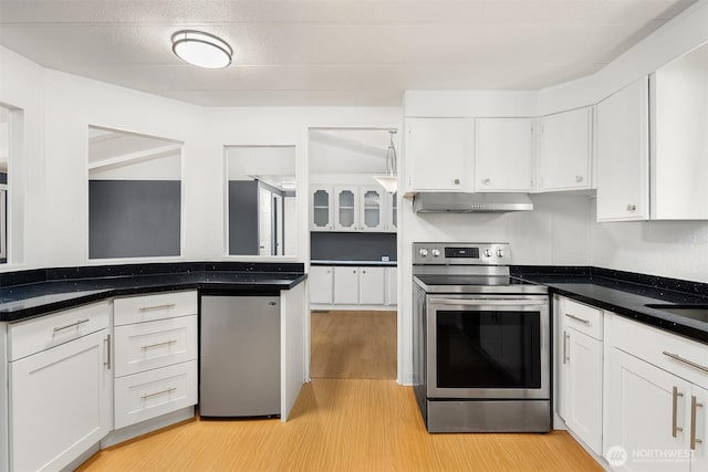 11500 Meridian Ave S Unit 22, Everett, WA 98208 - kitchen featuring light wood-type flooring, stainless steel electric stove, white cabinetry, refrigerator, and under cabinet range hood