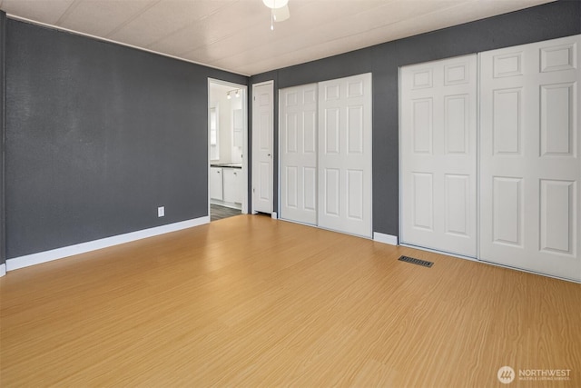 11500 Meridian Ave S Unit 22, Everett, WA 98208 - unfurnished bedroom featuring wood finished floors, multiple closets, and ensuite bath
