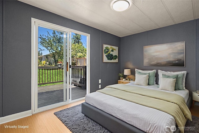 11500 Meridian Ave S Unit 22, Everett, WA 98208 - bedroom with wood finished floors, access to exterior, and a textured wall