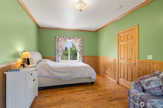 3613 Mcmullan Rd, Wenatchee, WA 98801 - bedroom with a wainscoted wall, wooden walls, crown molding, and light wood-type flooring