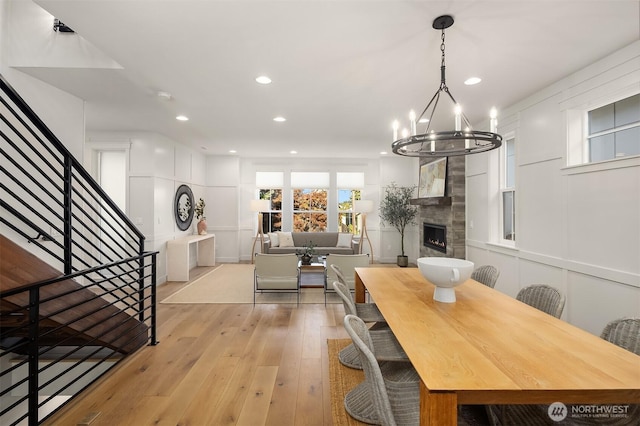8841 Dibble Ave NW, Seattle, WA 98117 - dining area featuring light wood-style flooring, stairs, a chandelier, recessed lighting, and a fireplace
