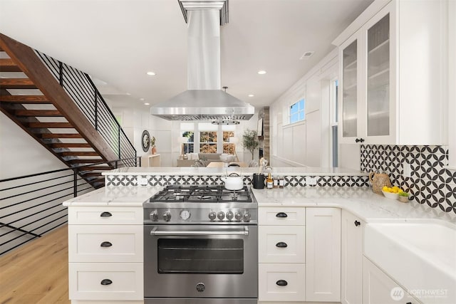 8841 Dibble Ave NW, Seattle, WA 98117 - kitchen featuring high end stove, a peninsula, white cabinets, light wood-type flooring, and recessed lighting