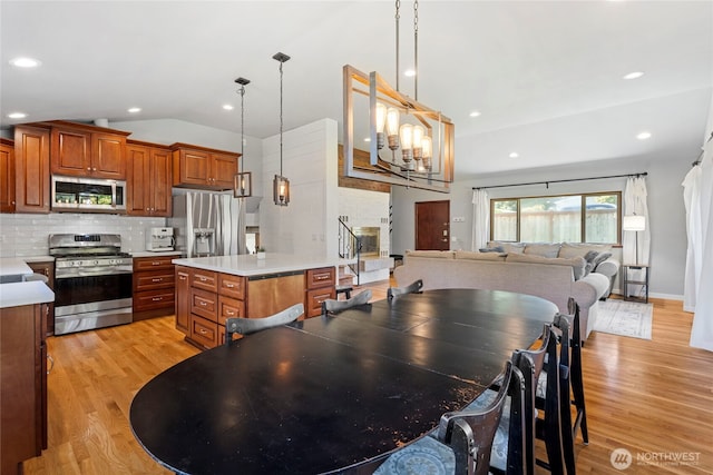 922 SW 160th St, Burien, WA 98166 - kitchen with appliances with stainless steel finishes, light countertops, light wood finished floors, brown cabinets, and vaulted ceiling