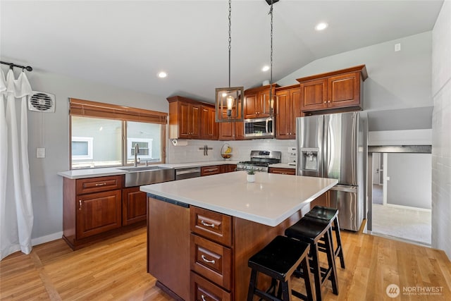 922 SW 160th St, Burien, WA 98166 - kitchen with stainless steel appliances, a breakfast bar, a center island, light countertops, and vaulted ceiling